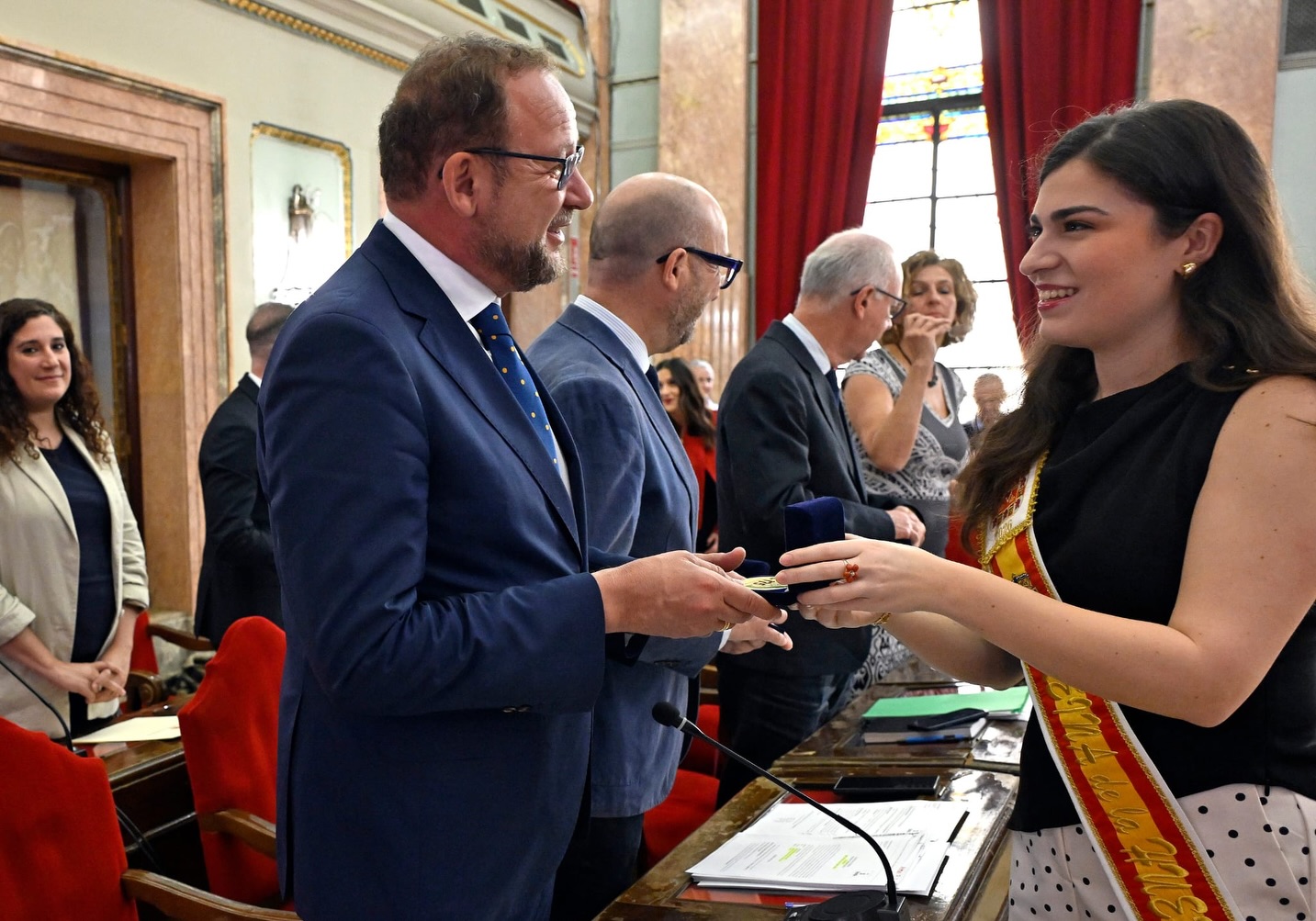 🌺✨ En el día de ayer, la Federación de Peñas Huertanas de la Región de Murcia acordó, antes del comienzo del Pleno en el Excmo. Ayuntamiento de Murcia, hacer entrega de una Medalla Conmemorativa del “175 Aniversario del Bando de la Huerta de Murcia” a la Excma. Sra. Alcaldesa de Murcia y a cada un@ de l@s concejal@s de la Corporación Municipal.
Asimismo, se entregó una medalla para que sea trasladada a la familia del Excmo. Sr. D. José Francisco Ballesta Germán, recientemente fallecido. D.E.P. Amén 🙏✝️💐, así como al Sr. Secretario del Ayuntamiento.
Al acto asistieron nuestro Presidente Juan García Serrano, nuestra Presidenta Fuensanta Martínez Martínez y la Reina de la Huerta Ángela Muñoz Briones. 🌸👑
Un emotivo reconocimiento a la historia, tradición y legado de nuestras Fiestas de Primavera y del Bando de la Huerta 🌺💚
#FederacionDePeñasHuertanas #BandoDeLaHuerta #175Aniversario #Murcia #FiestasDePrimavera